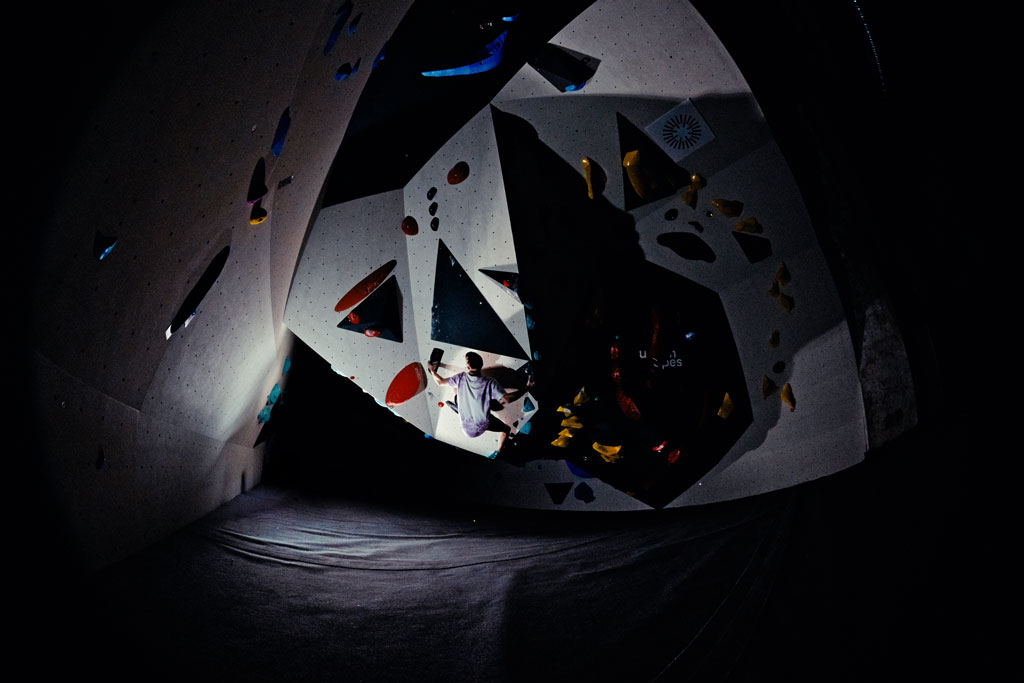 Boulderer an einem Überhang in einem gewölbten Raum im urban apes Fhain Berlin